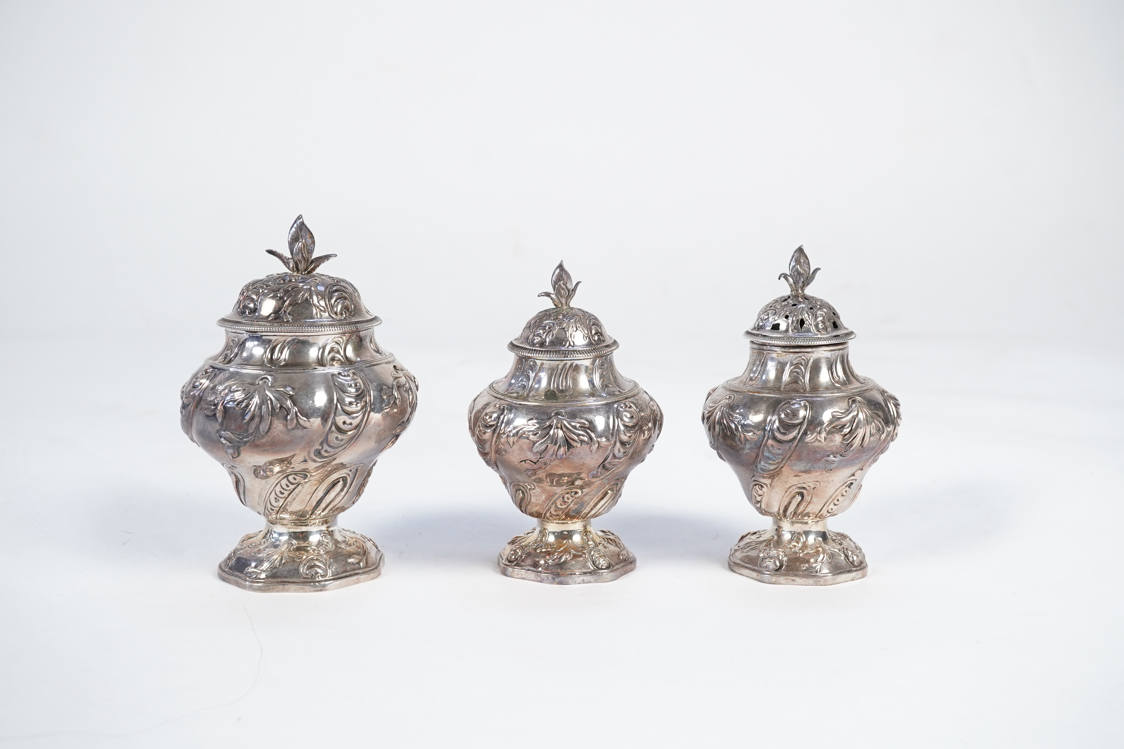 A George II mahogany cased set of two early George III silver tea caddies and covers and a sugar vase and cover, by Samuel Herbert & Co